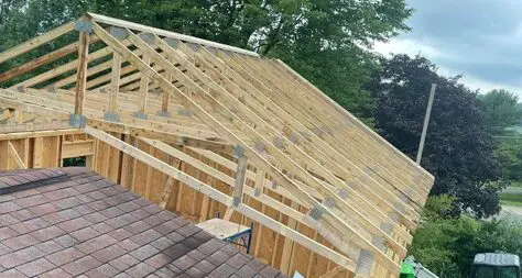 A wooden roof structure being built on top of a brick building.