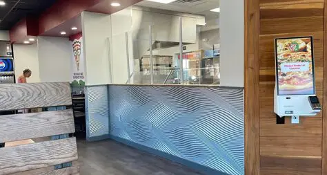 A restaurant with a large counter and a glass wall.
