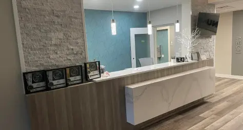 A reception area with a large counter and a mirror.